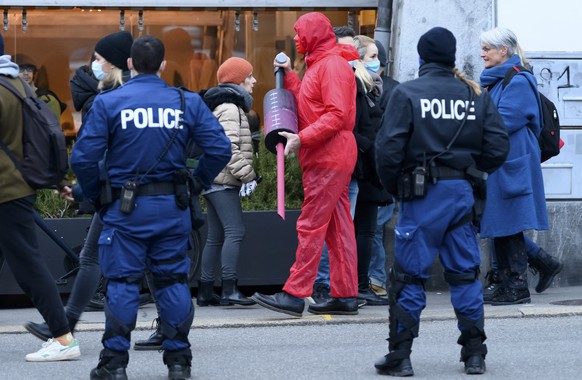 Ein Mann mit einer grossen Attrappe einer Impfspritze demonstriert gegen die Corona-Schutzmassnahmen des Bundes und wird von Polizisten ueberwacht, am Samstag, 19. Dezember 2020, auf dem Bundesplatz i ...