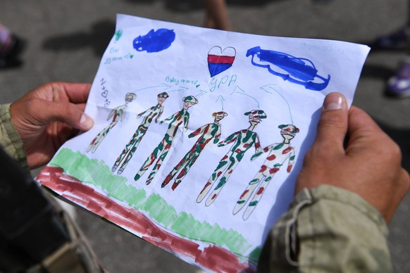 Ukraine Russia Military Operation School 8242444 21.07.2022 Russian serviceman looks at children s drawing outside a school as Russia s military operation in Ukraine continues, in one of the settlemen ...