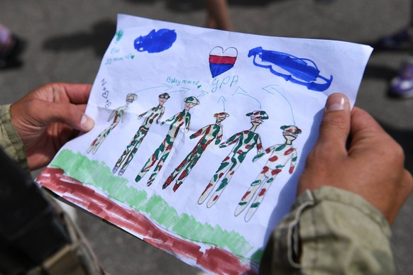 Ukraine Russia Military Operations School 8242444 7/21/2022 Russian soldier looks at children's drawings outside a school as the Russian military operation continues in Ukraine, in one of the settlements ...