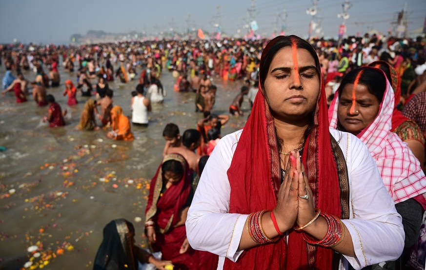 epaselect epa11858115 Hindu devotees take a dip and pray ahead of the second sacred bathing ritual, or 'Shahi Snan', during the Kumbh Mela festival at Sangam, the confluence of the holy rive ...