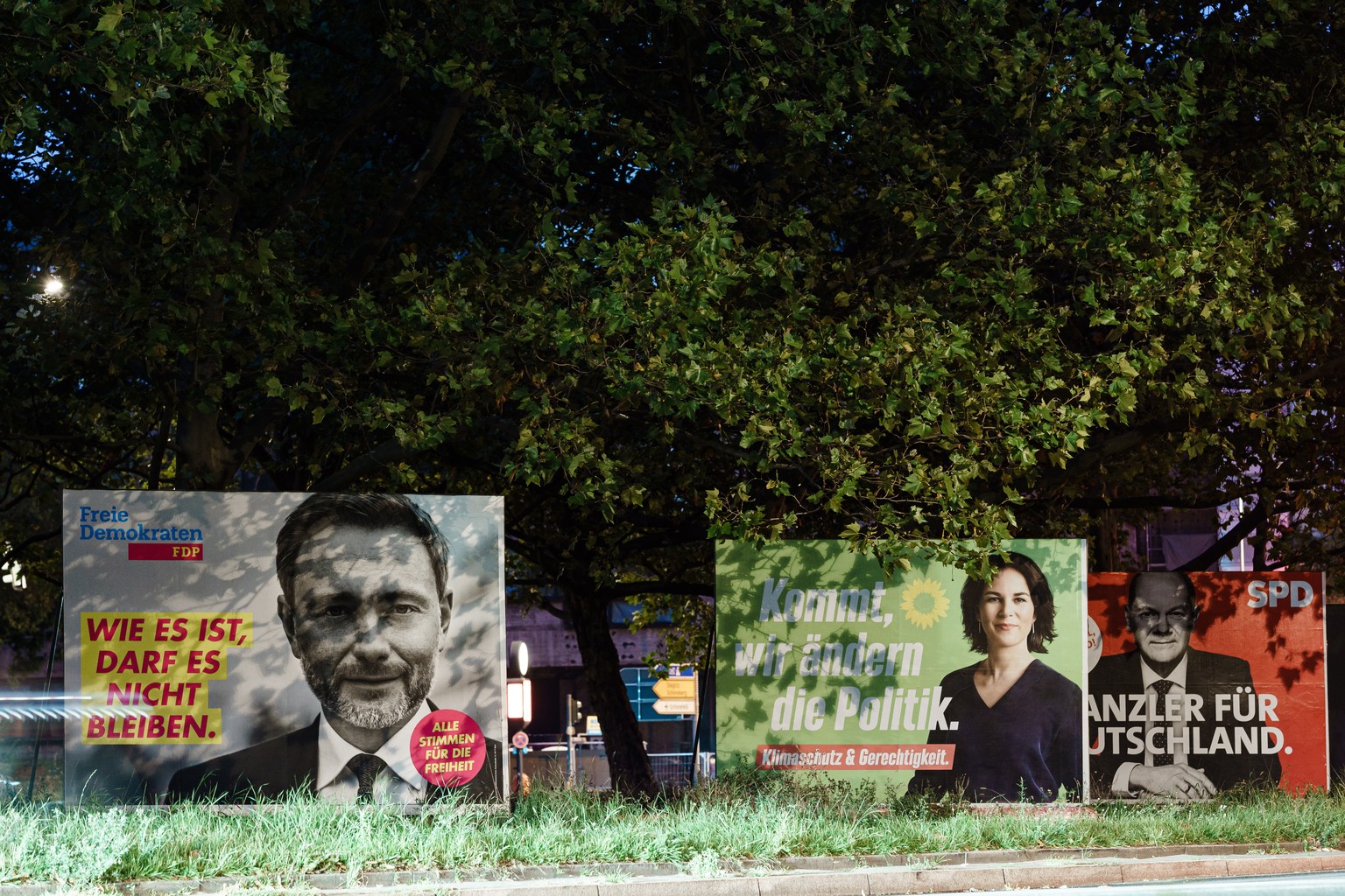 epa09488199 Campaigning posters of the Liberal party (FDP) (L), Green party (C) and the Social Democrats (R) show the top candidates Christian Lindner (L), Annalena Baerbock (C) and Olaf Scholz (R) in ...