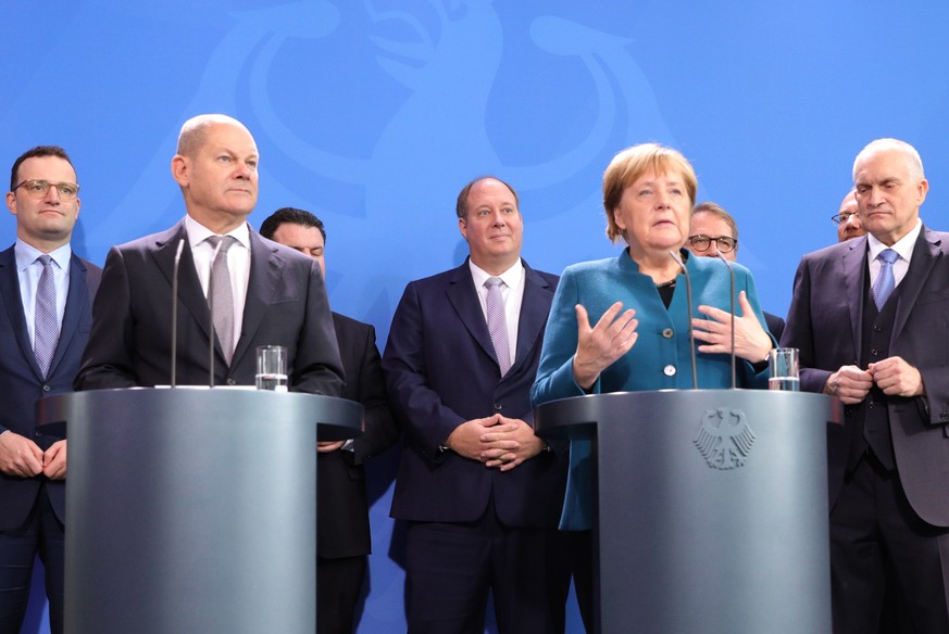 epa07975906 German Chancellor Angela Merkel (R) and Minister of Finance Olaf Scholz (L) deliver a staement during the Annual Report 2019/2020 on the Assessment of Macroeconomic Development by the Germ ...