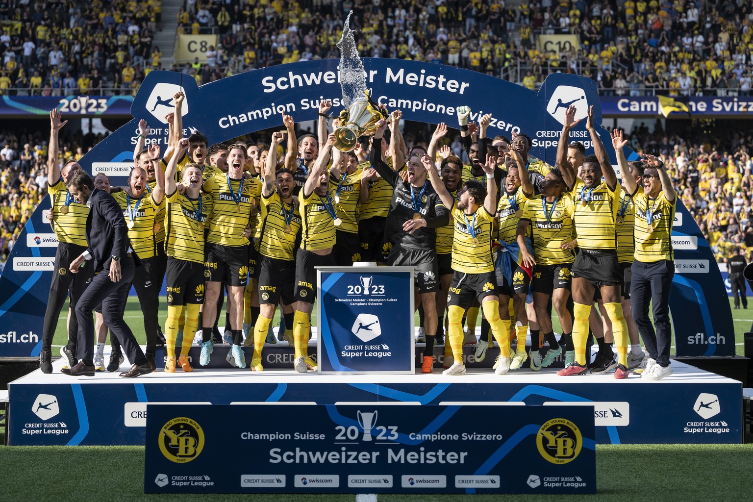 Die YB Spieler jubeln mit dem Pokal des Schweizerfussballmeisters, waehrend der Pokalueberbringer Claudius Schaefer, CEO der Swiss Football League SFL, links, eilends die Buehne verlaesst, nach dem Fu ...