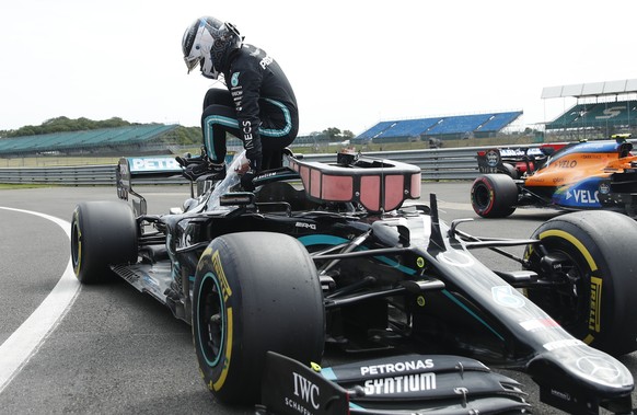 Mercedes driver Valtteri Bottas of Finland jumps out of his car as he celebrates setting the fastest time, during qualifying for the 70th Anniversary Formula One Grand Prix at the Silverstone circuit, ...