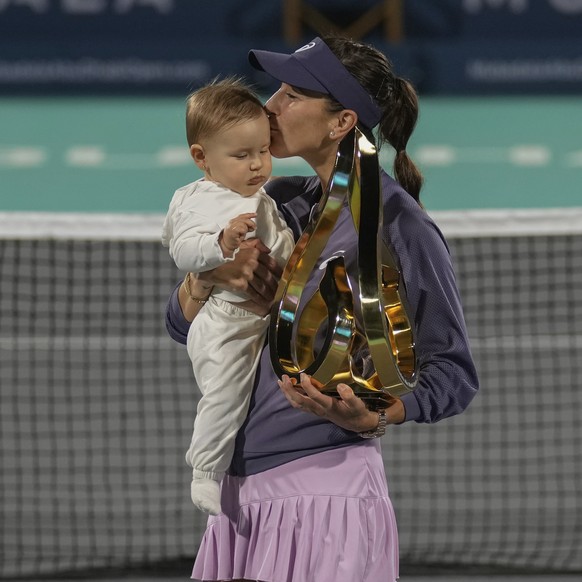 Belinda Bencic of Switzerland kisses her daughter while holding the winning trophy during award ceremony after winning against Ashlyn Krueger of United States in the Women's single final match of ...