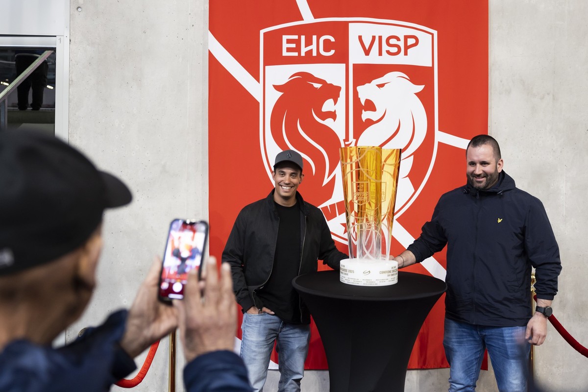 Fans des EHC Visp fotografieren sich mit dem Meisterpokal vor dem zweiten Spiel der League Qualification der Eishockey National League zwischen dem EHC Visp und HC Ajoie, am Donnerstag, 3. April 2025  ...