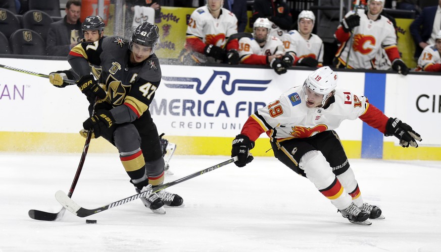 Vegas Golden Knights defenseman Luca Sbisa (47) and Calgary Flames center Matthew Tkachuk reach for the puck during the second period of an NHL hockey game Wednesday, Feb. 21, 2018, in Las Vegas. (AP  ...