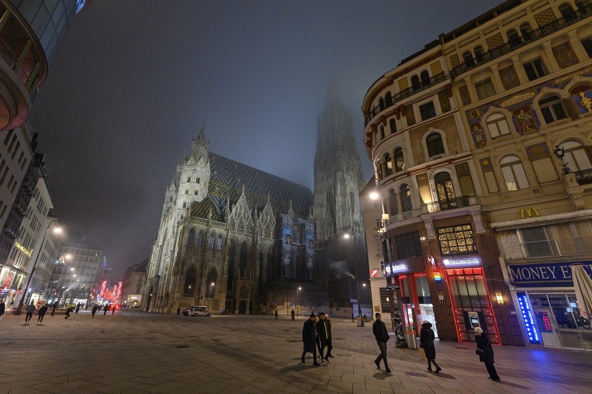 epa08913431 People gather to celebrate the New Year?s Eve at the Stephansplatz square in front of the Saint Stephen's Cathedral during a nationwide COVID-19 lockdown in Vienna, Austria, 31 Decemb ...