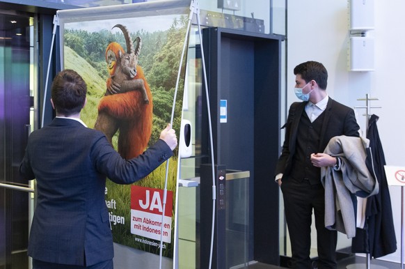 Ein Mitglied des Komitees stellt ein Abstimmungsplakat neben Fabian Molina, Nationalrat SP-ZH, Mitte, und Laurent Wehrli, Nationalrat FDP-VD, rechts, in den Lift, am Ende einer Medienkonferenz des Kom ...