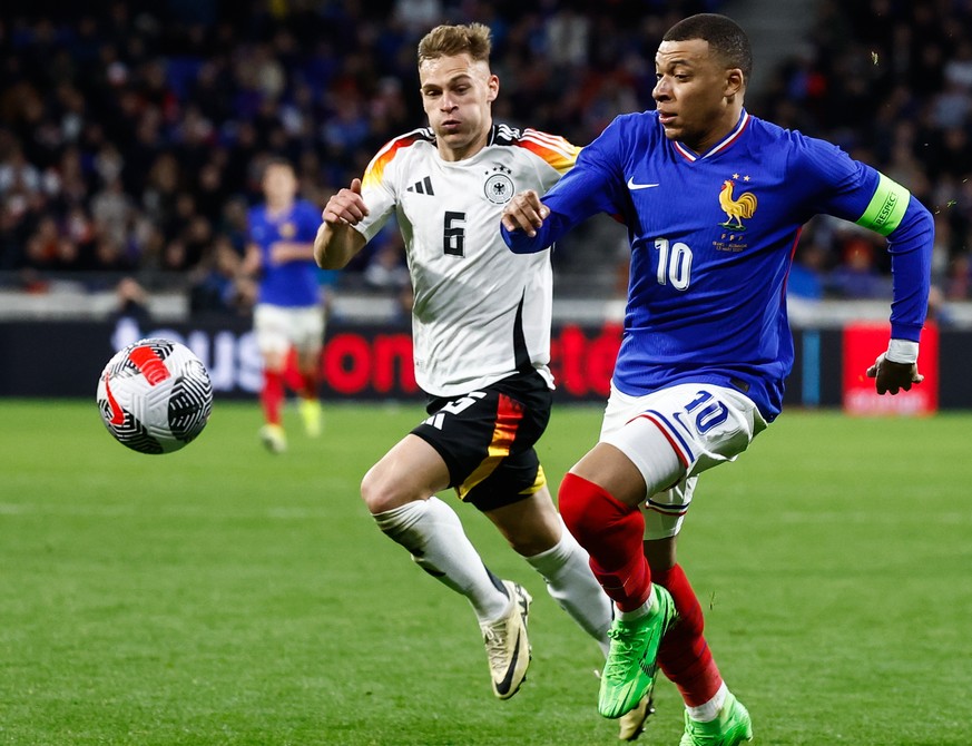 epa11240242 Joshua Kimmich (L) of Germany in action against Kylian Mbappe (R) of France during a friendly international soccer match between France and Germany at Groupama Stadium, in Decines-Charpieu ...