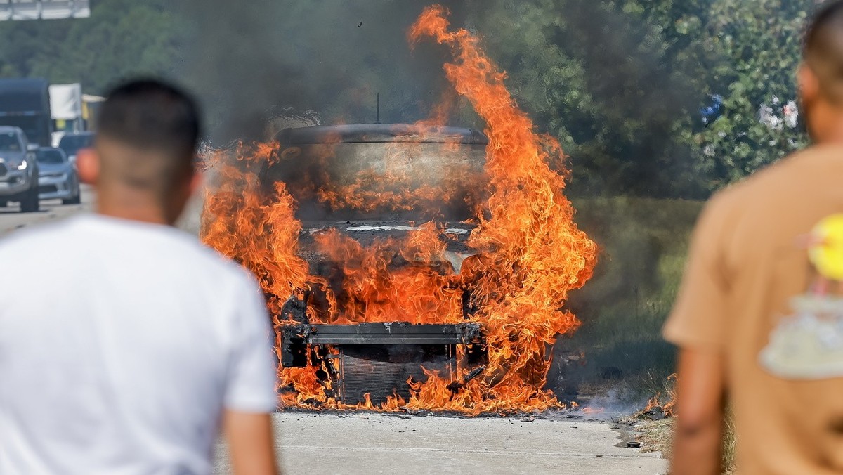 epa11651375 People watch as a motorist's Kia Soul catches fire on Interstate 675 in Ellenwood, Georgia, USA, 09 October 2024. The fire and traffic slowdown added to highway congestion in the area ...