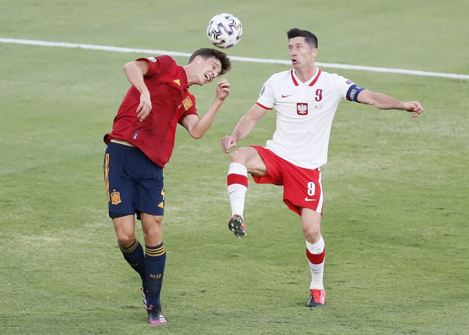 Poland's Robert Lewandowski, right, and Spain's Aymeric Laporte challenge for the ball during the Euro 2020 soccer championship group E match between Spain and Poland at Estadio de la Cartuja stadium  ...
