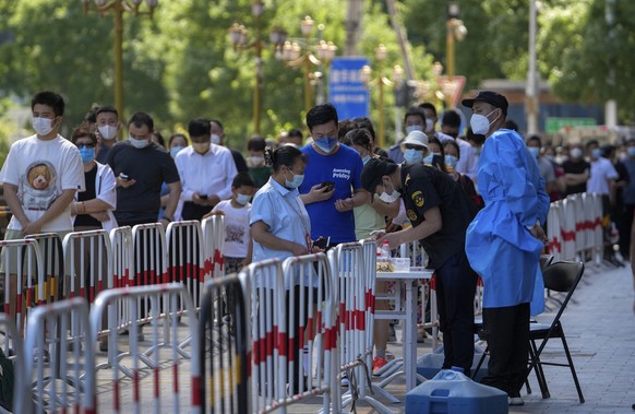 Residents line up for coronavirus testing set up outside a residential complex in Beijing, Monday, May 30, 2022. (AP Photo/Andy Wong)