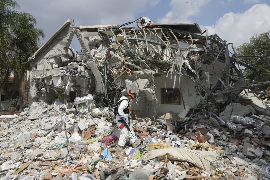 An Israeli soldier walks by a house destroyed by Hamas militants in kibbutz Be&#039;eri on Wednesday, Oct. 11, 2023. The kibbutz was overrun by Hamas militants from Neraby Gaza Strip Saturday when the ...