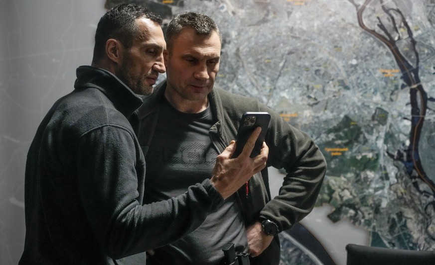 Vitali Klitschko, Kyiv Mayor and former heavyweight champion, right, and his brother Wladimir Klitschko, a Ukrainian former professional boxer look at a smart phone in the City Hall in Kyiv, Ukraine,  ...