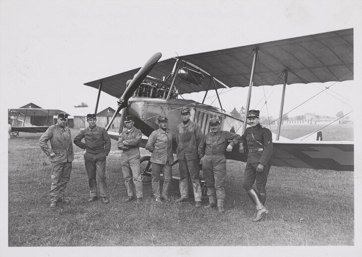 Leutnant Oskar Bider (ganz rechts) mit seinen Flugschülern vor einem Flugzeug auf dem Flugplatz Dübendorf ca. 1914-1919.