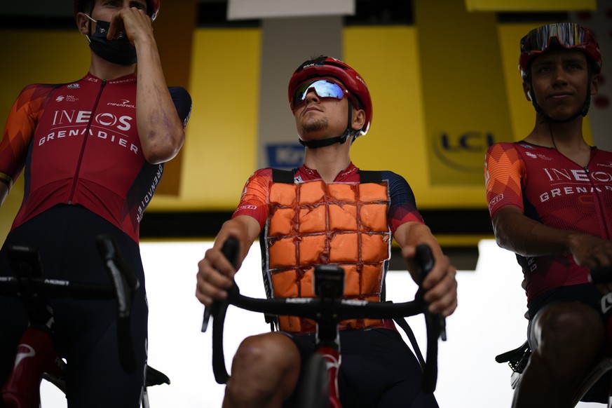 Britain's Thomas Pidcock wears an ice vest as he stands next to teammate Colombia's Egal Bernal, right, prior to the eleventh stage of the Tour de France cycling race over 180 kilometers (11 ...