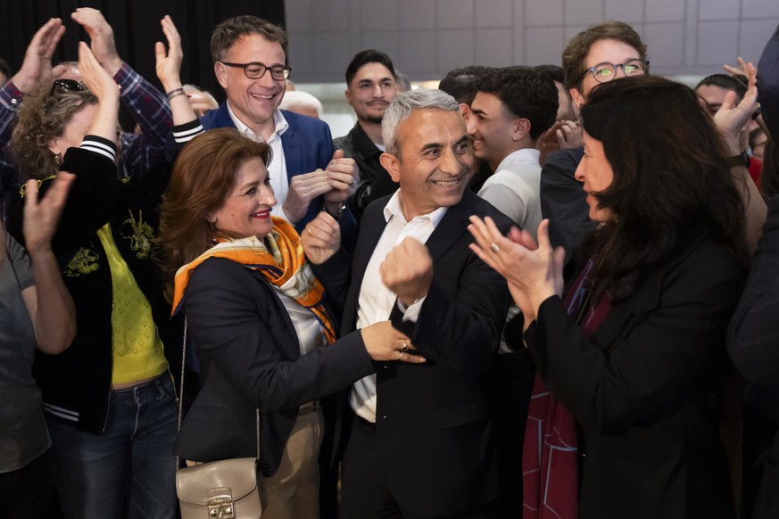Mustafa Atici, neu gewaehlter Regierungsrat Basel-Stadt, Mitte, und seine Frau Cennet, Mitte links, freuen sich mit Regierungsraetin Tanja Soland, rechts, und ihren Anhaengern nach den Schlussresultat ...