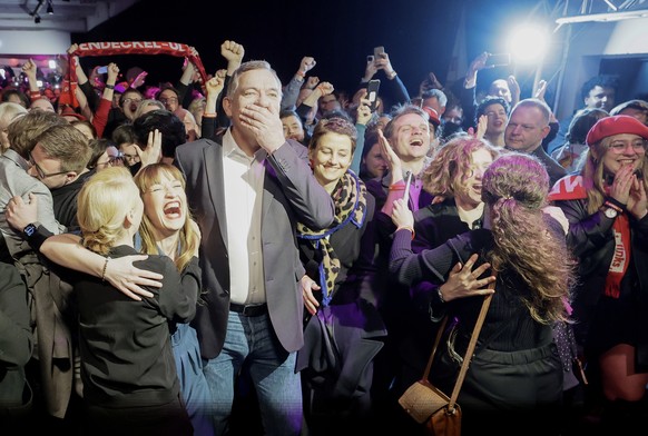 epa11919324 Heidi Reichinnek (2-L), top candidate for the Left Party (Die Linke), co-leaders Jan van Aken (3-L) and Ines Schwerdtner (L), react with party members to initial results during the party e ...