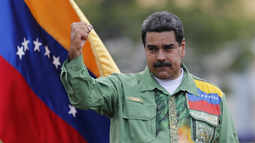 Venezuela&#039;s President Nicolas Maduro raises his fist during a closing campaign rally in Caracas, Venezuela, Thursday, May 17, 2018. Maduro is seeking a new six-year mandate and despite crippling  ...