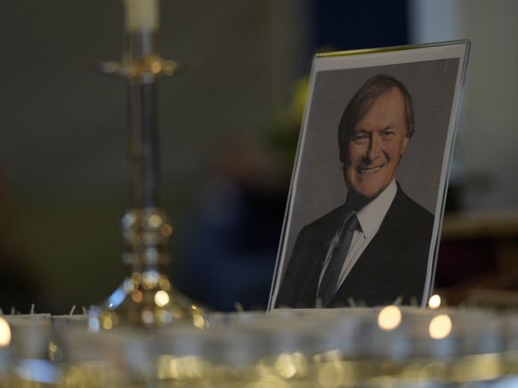 Candles are lit next to a portrait of British Lawmaker David Amess during a vigil for him at St Michaels Church, in Leigh-on-Sea, England Sunday, Oct. 17, 2021. Amess was killed on Friday during a mee ...