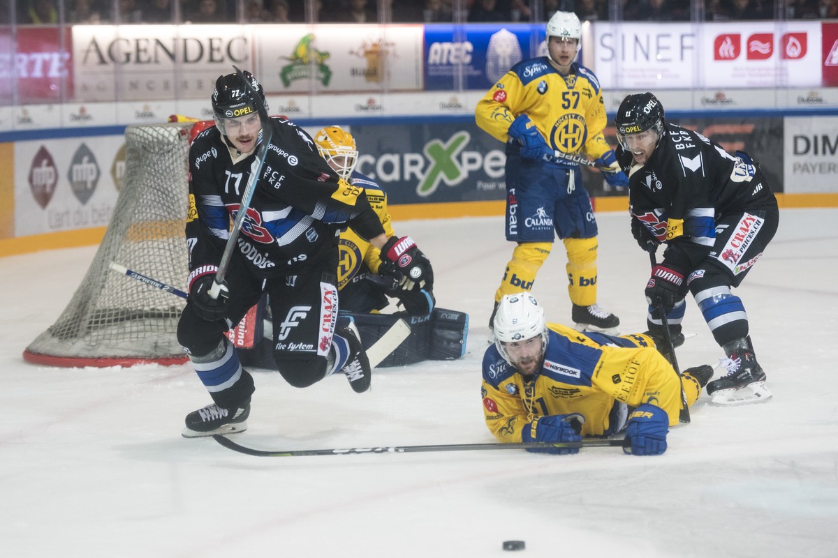 Le defenseur fribourgeois Sebastian Schilt, gauche, lutte pour le puck avec l'attaquant davosiens Fabian Heldner, centre, et l'attaquant fribourgeois Lukas Lhotak, droite, lors de la rencont ...