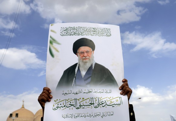 epa13103341 A Houthi supporter holds a poster showing the late Iranian Supreme Leader Ali Khamenei during a protest in solidarity with the Iranian people, and against US airstrikes on Iran, in Sana  ...