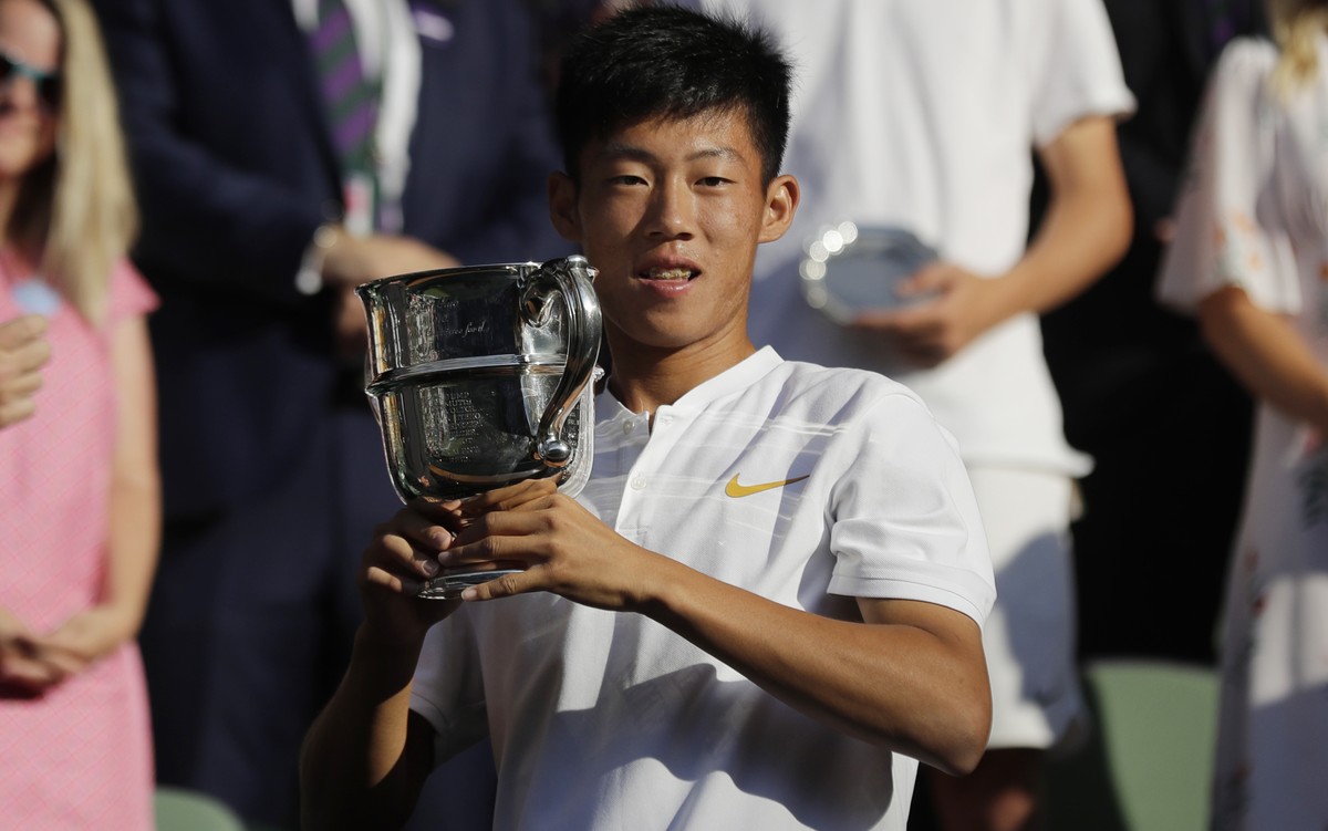 Tseng Chun Hsin of Taiwan kisses the trophy after defeating Jack Draper of Britain in the boys' singles final at the Wimbledon Tennis Championships in London, Sunday July 15, 2018. (AP Photo/Ben  ...