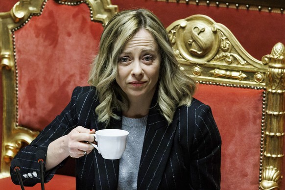 Italian Premier Giorgia Meloni drinks coffee as she addresses the Senate in Rome Wednesday, Dec. 13, 2023. (Roberto Monaldo/LaPresse via AP)