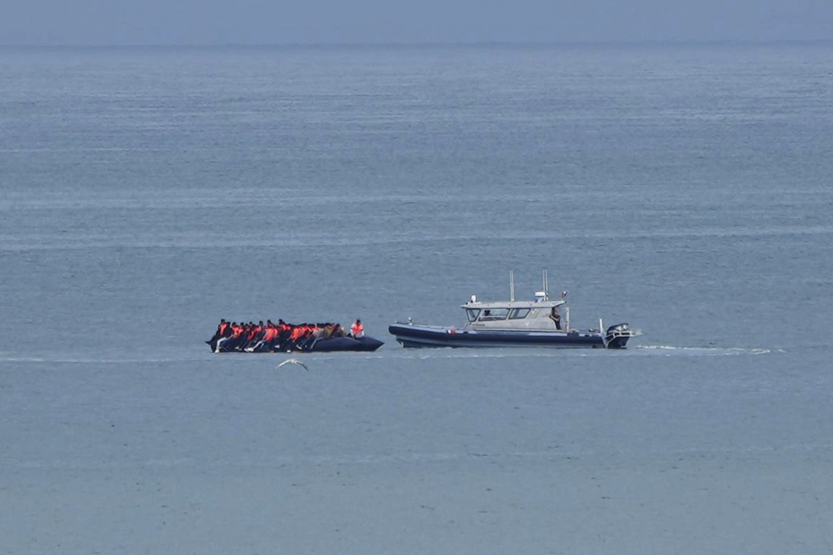 FILE - A boat thought to carry migrants is escorted by a vessel from the French Gendarmerie Nationale in the English Channel off Wimereux beach, France, Wednesday, Sept. 4, 2024. (AP Photo/Nicolas Gar ...
