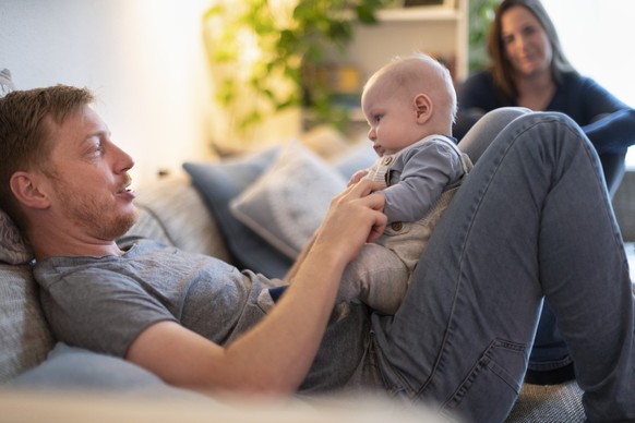Ein Vater umsorgt an seinem freien Tag gemeinsam mit seiner Frau zu Hause seinen vier Montate alten Sohn, fotografiert am 15. Mai 2020 in Aarau. (KEYSTONE/Gaetan Bally)