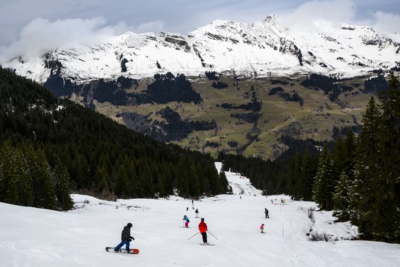 Des skieurs descendent la piste du domaine skiable entre Les Mazots et Les Diablerets le mardi 27 decembre 2022 dans les Alpes vaudoises. (KEYSTONE/Jean-Christophe Bott)