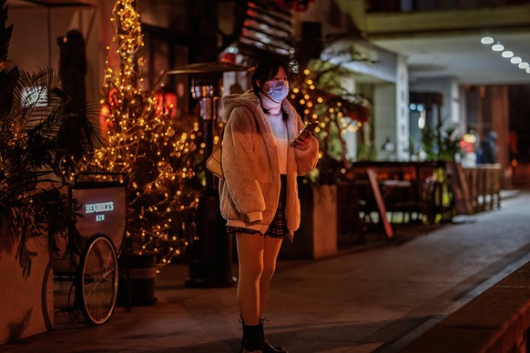 epa10370311 A woman stands on deserted street, in Shanghai, China, 17 December 2022. Shanghai?s schools are shifting to online from Monday due to the rise in COVID-19 cases. Kindergartens, nurseries,  ...