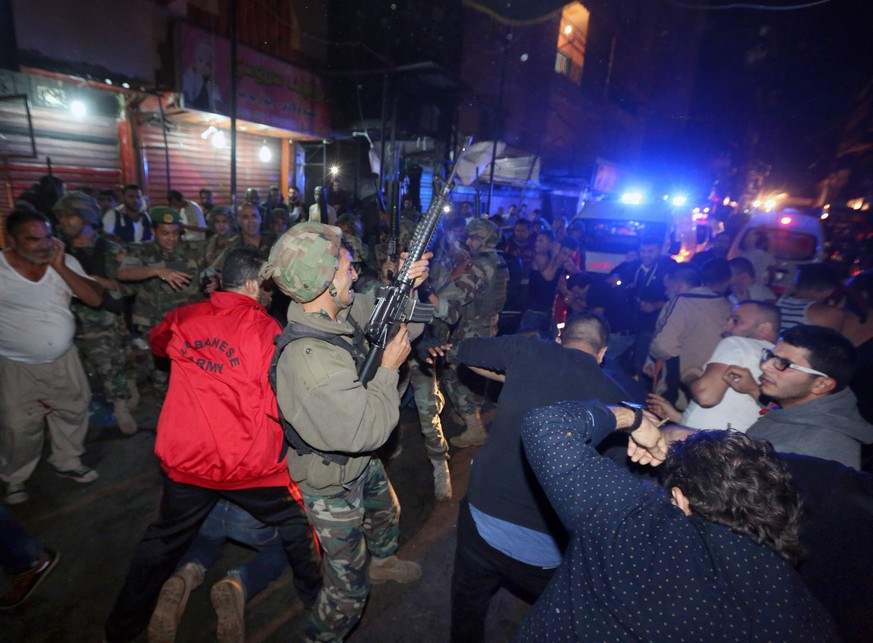 Chaotische Szenen nach den Detonationen: Regierungssoldaten feuern in die Luft, um die Menge vor Angriffen auf weitere, angebliche Selbstmordattentäter abzuhalten.