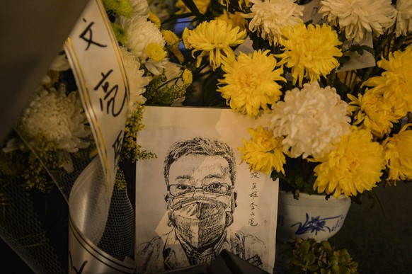 epa08200774 A card with a portrait of Dr. Li Wenliang at Li&#039;s hospital in Wuhan in central China&#039;s Hubei province, 07 February 2020. Li, regarded a whistleblower on the pneumonia outbreak, d ...