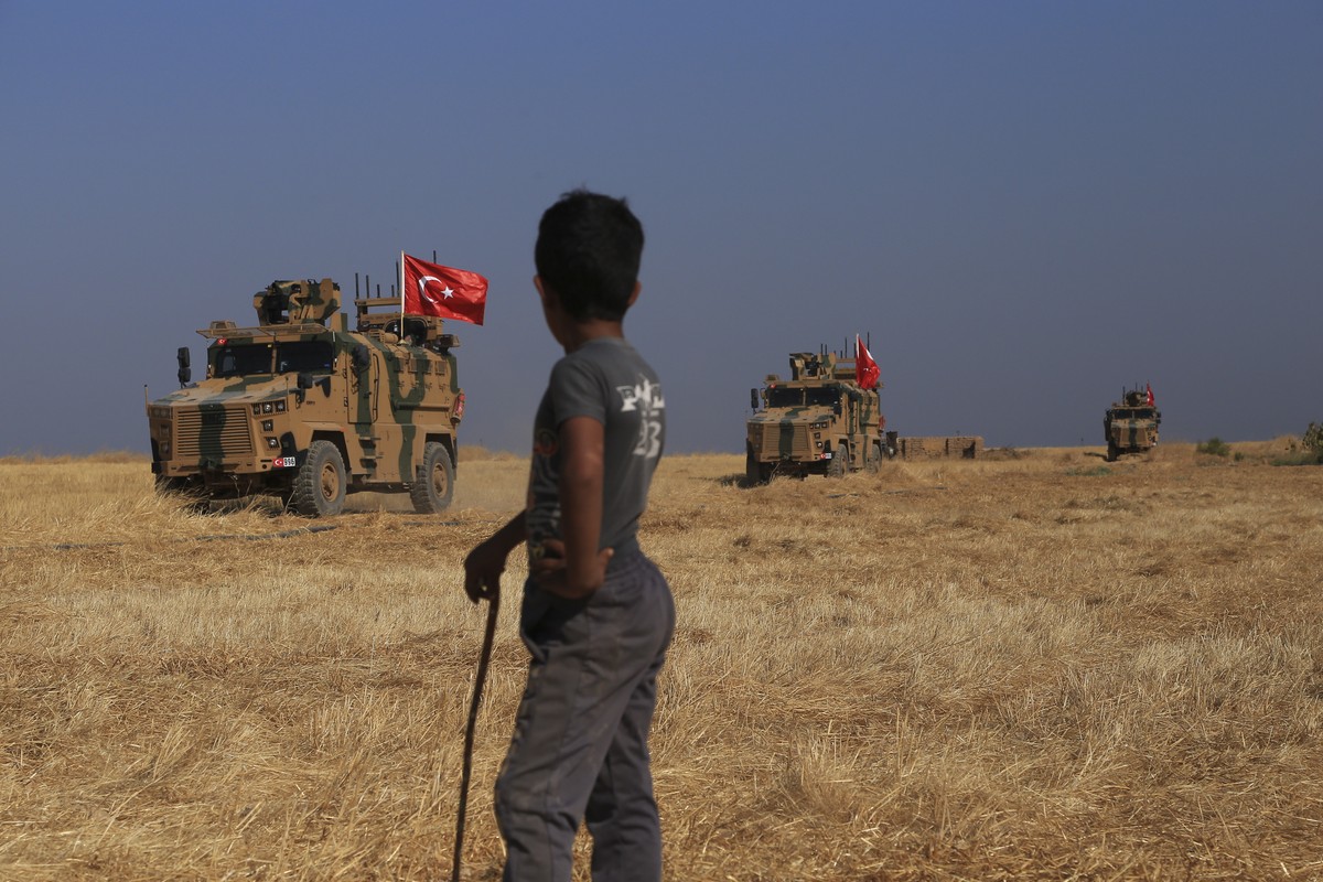 A Turkish n armored vehicles patrol as they conduct a joint ground patrol with American forces in the so-called "safe zone" on the Syrian side of the border with Turkey, near the town of Tal ...