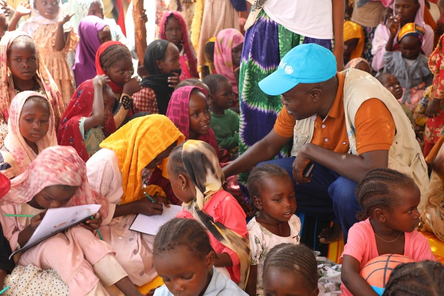 On 16 June 2023, UNICEF Chad child protection officer Valery Nodjimadji sits with children in a Child-Friendly space in Koufroun, a Chadian village in eastern Chad hosting refugees from Sudan. The Chi ...