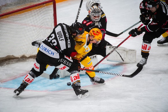 From left: Lugano&#039; player Bernd Wolf, Bern&#039;s player Dominik Kahun and Lugano&#039;s goalkeeper Niklas Schlegel, during the preliminary round game of National League Swiss Championship 2023/2 ...