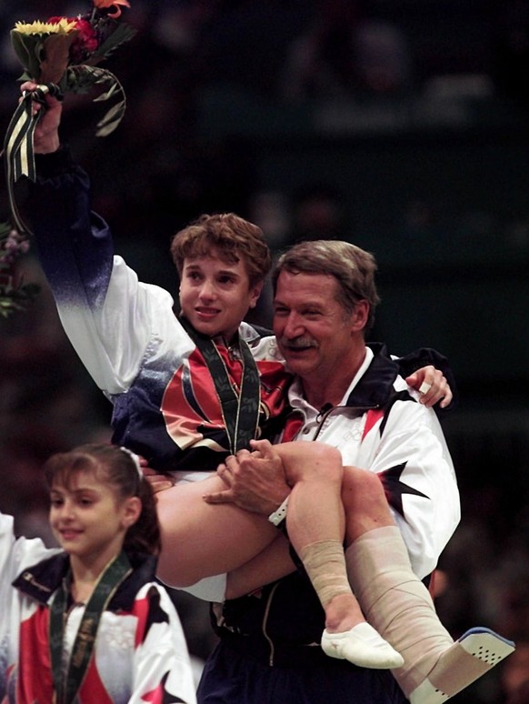 U.S. gymnastics coach Bela Karolyi carries injured Kerri Strug following the awarding ceremony at the women&#039;s team gymnastics competition at the Centennial Summer Olympic Games in Atlanta on Tues ...