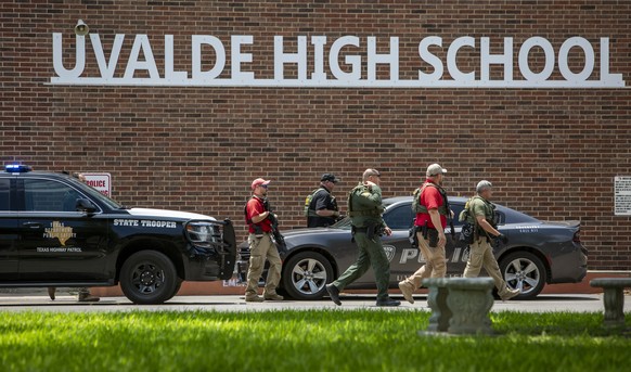 Law enforcement personnel walk outside Uvalde High School after shooting a was reported earlier in the day at Robb Elementary School, Tuesday, May 24, 2022, in Uvalde, Texas. (William Luther/The San A ...
