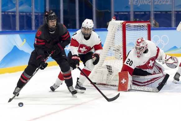 Canada&#039;s forward Brianne Jenner, left, vies for the puck with Switzerland&#039;s defender Sarah Forster, center, past Switzerland&#039;s goaltender Andrea Braendli, right, during the preliminary  ...