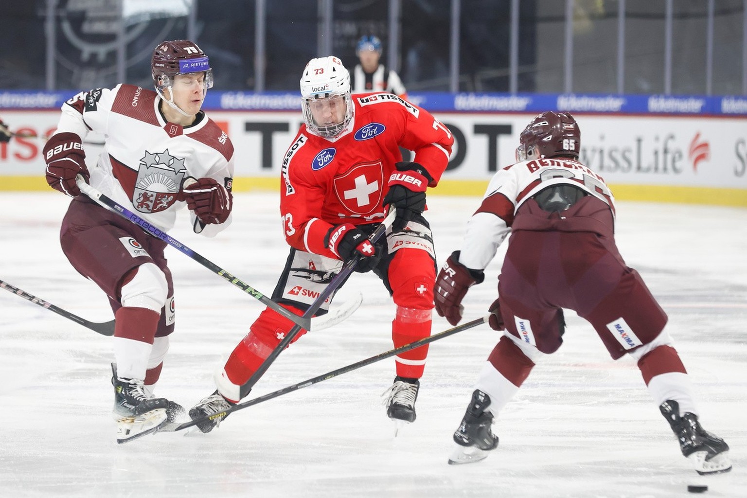 Switzerlands Mike Kuenzle, right, in action against Latvias Roberts Kalkis during an ice hockey World Cup preparation match between Switzerland and Latvia at the Stimo Arena in Kloten, Switzerland, Sa ...