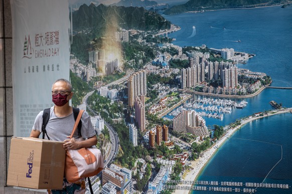 epa09467102 A man walks past an advertising for Emerald Bay, a China Evergrande real estate project in Hong Kong, displayed outside the China Evergrande Centre in Wanchai, Hong Kong, China, 14 Septemb ...