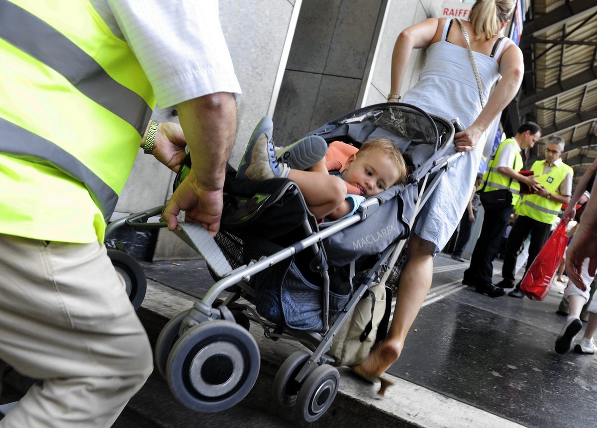 Ein Bahnhofsangestellter hilft einer Frau den Kinderwagen die Treppen hinaufzutragen, nach einem Stromausfall im Hauptbahnhof Zuerich, am Mittwoch, 21. Juli 2010. Der Stromausfall legt die Beleuchtung ...