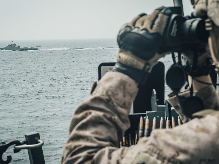 Ein US-Soldat beobachtet ein iranisches Schiff in der Strasse von Hormus. (Foto: US MARINE CORPS/STAFF SGT. DONALD HOLBERT via EPA Keystone)