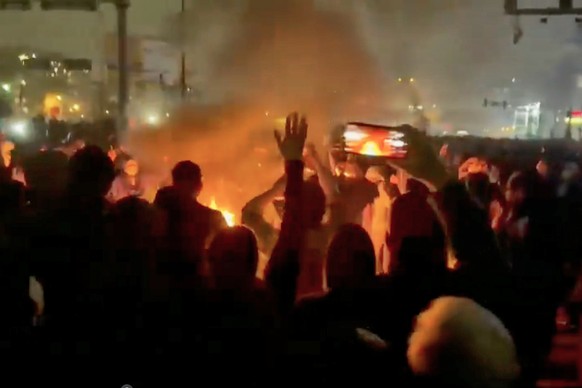 In this frame grab from footage circulating on social media shows protesters dancing and cheering around a bonfire as they take to the streets despite an intensifying crackdown as the Islamic Republic ...