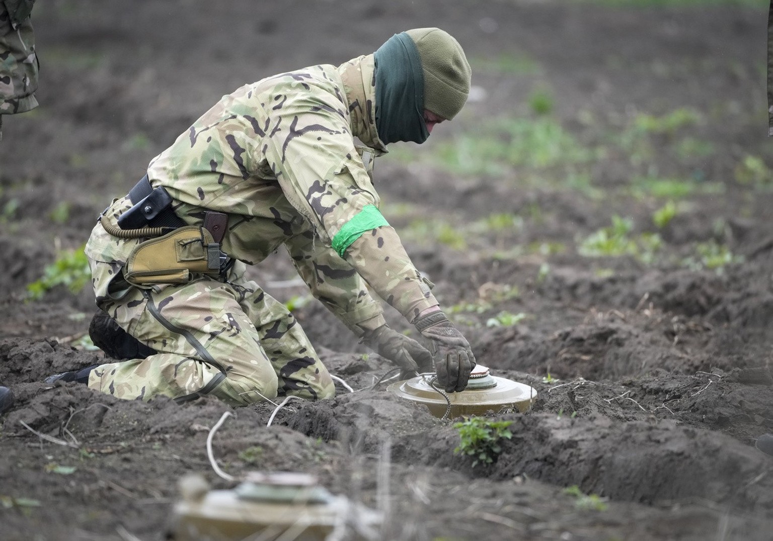 An Interior Ministry sapper defuses a mine in a minefield after recent battles in Irpin, close to Kiev, Ukraine, Tuesday, April 19, 2022. (AP Photo/Efrem Lukatsky)