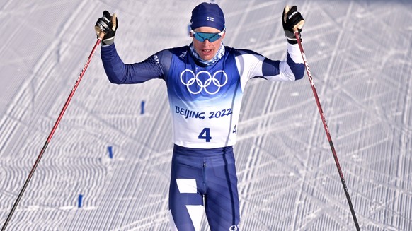 epa09731891 Third placed Iivo Niskanen (R) of Finland crosses the finish line during the Men's 15km+15km Skiathlon event at the Zhangjiakou National Cross-Country Skiing Centre at the Beijing 202 ...
