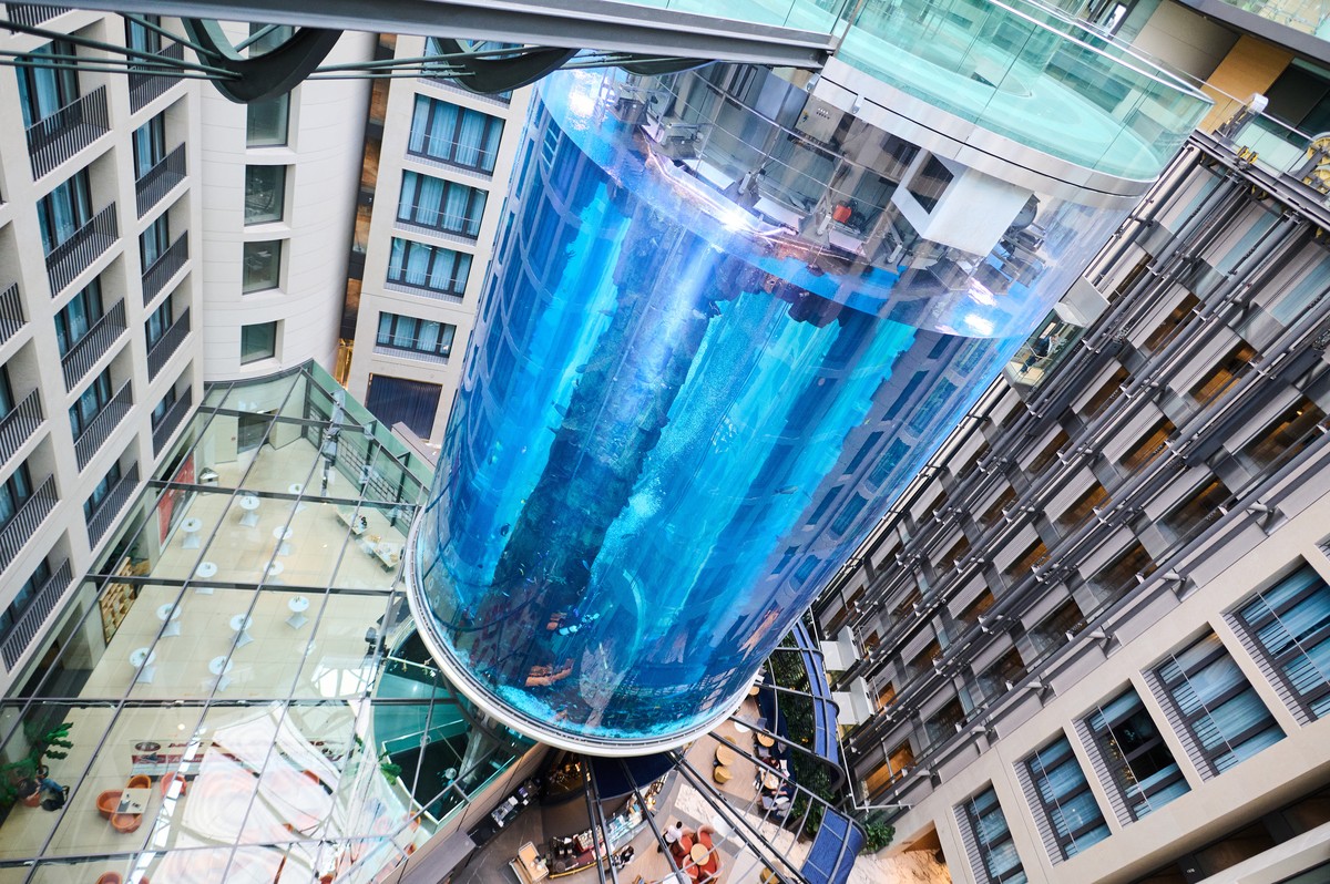 ARCHIV - 01.06.2022, Berlin: Der AquaDom im SEA LIFE nach Sanierungsarbeiten. Das riesige Aquarium in einem Hotel ist in der Nacht zum 16.12.2022 leck geschlagen. Wasser str�mte dabei bis auf die Stra ...