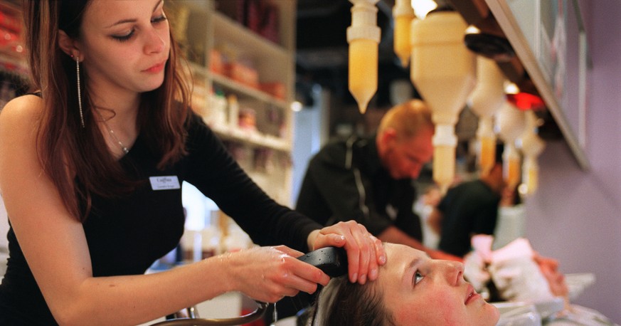 Ein Coiffeur-Lehrling waescht am 23. April 2003 einer Kundin die Haare im Coiffeur Salon Coiffina in Zuerich. (KEYSTONE/Gaetan Bally) : FILM]